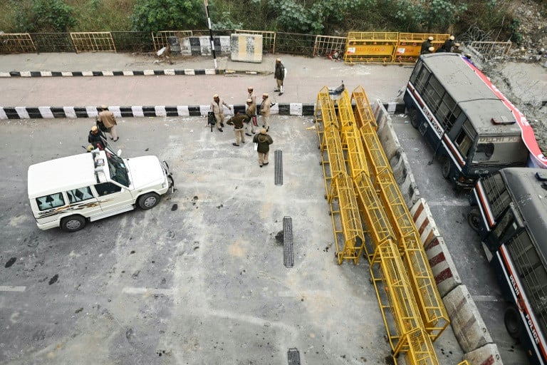 While protesting farmers march towards the capital, Indian police use tear gas