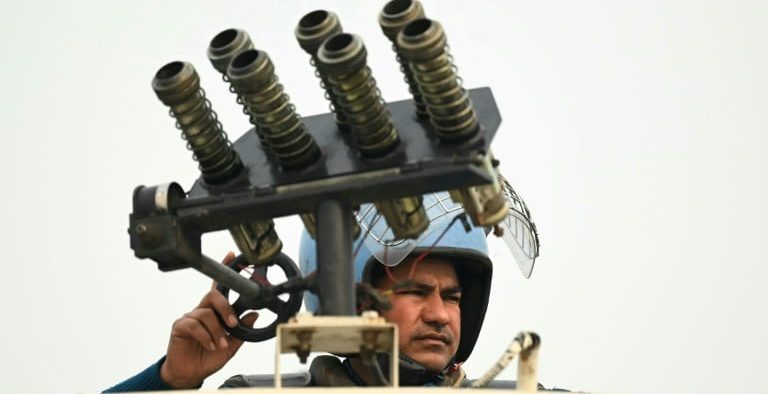 While protesting farmers march towards the capital, Indian police use tear gas