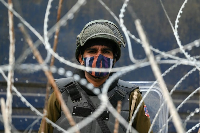 While protesting farmers march towards the capital, Indian police use tear gas